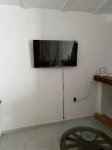 een flatscreen-tv op een witte muur met een wiel bij capitan in El Rompido