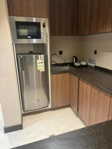 a kitchen with a stainless steel refrigerator and a sink at ايليت الخالدية in Medina