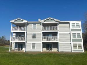 a large apartment building with a lawn in front of it at One Bedroom Unit at Acadia Village Resort in Ellsworth