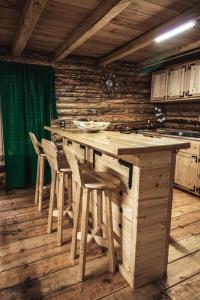 a kitchen with a wooden table and stools at Cabañas Los Encinos in Acaxochitlán +8 photos