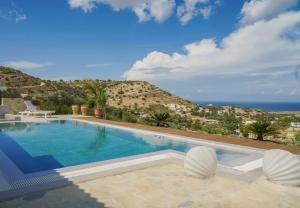 a swimming pool with a view of the ocean at Brand new comfortable villa Ganesha In Pitsidia, Matala ,Kalamaki in Pitsidia