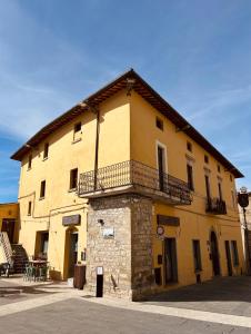 un edificio giallo con balcone sul lato di LocAle Guest House a Pietralunga