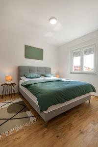 a bedroom with a large bed with a green blanket at Kuća za odmor Finida in Umag