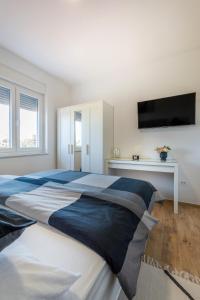 a bedroom with a large bed with a tv on the wall at Kuća za odmor Finida in Umag