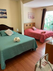 una habitación de hotel con 2 camas y una maleta en Uli´s house en Lima