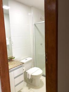 une salle de bain blanche avec toilettes et douche dans l'établissement Beachfront apartment, à Vila Velha