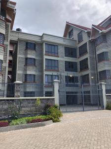 a building with a fence in front of it at Vogue Homes in Nakuru