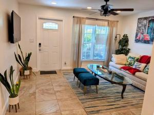 uma sala de estar com um sofá e uma mesa de vidro em The Ave House- Private Oasis Retreat W/heated Pool em Fort Lauderdale