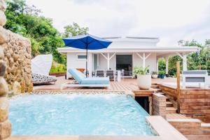 uma piscina com um guarda-sol e uma casa em Luxury Beachfront Villa at Punta Flamenco, Culebra, Puerto Rico em Culebra
