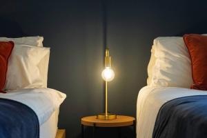 a lamp on a table next to two beds at Luxury Campbell Park Apartments in Central MK with Balcony, Free Parking & Smart TV with Netflix by Yoko Property in Milton Keynes