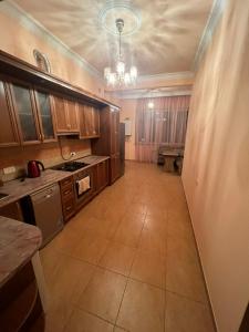 a large kitchen with wooden cabinets and a tile floor at Opera Guest House in Yerevan