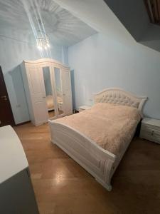 a bedroom with a white bed and a cabinet at Opera Guest House in Yerevan