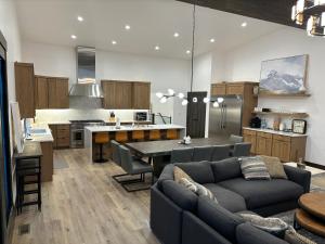 a kitchen and living room with a couch and a table at Whitefish Mountain Marvel Ski in Ski out- New Build, Pool Table, Hot Tub and Sleeps 19! in Whitefish
