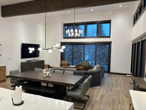 a living room with a table and a couch at Whitefish Mountain Marvel Ski in Ski out- New Build, Pool Table, Hot Tub and Sleeps 19! in Whitefish
