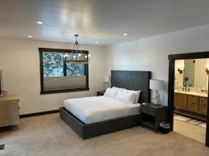 a bedroom with a bed and a mirror and a sink at Whitefish Mountain Marvel Ski in Ski out- New Build, Pool Table, Hot Tub and Sleeps 19! in Whitefish