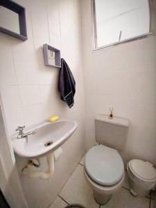 a white bathroom with a toilet and a sink at Apto 3 quartos, no Centro. Temático e acolhedor! in Nova Friburgo +16 photos