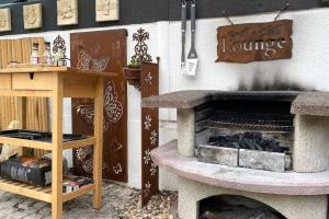 un patio con una chimenea de piedra y una mesa en Marcel Bruckmanns Spa - Wellness & Holiday Apt. en Erkrath