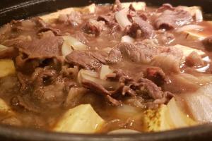 a pot of food with meat and onions at Dormy Inn Express Koriyama in Koriyama