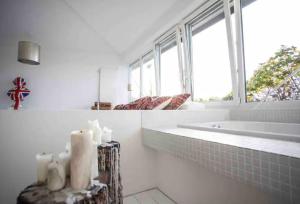 a white bathroom with a tub and a window at Whiteloft in Neuwied