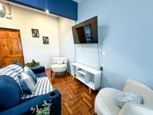 sala de estar con sofá azul y TV en Beachfront w/ pool & rancho - Casa Coral en Puntarenas