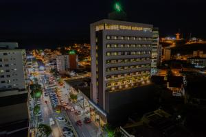 un edificio alto en una ciudad por la noche en HOTEL GRAN PREMIUM PLAZA LTDA, en Muriaé