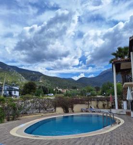 a swimming pool with mountains in the background at HENNA VILLA in Fethiye
