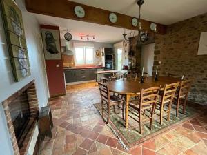 cocina y comedor con mesa de madera y sillas en Maison familiale, 15 pers, 7 chambres, piscine, déco soignée, en Bais