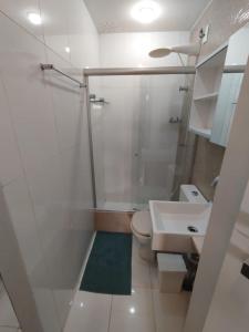 a bathroom with a white toilet and a sink at Queen's Flats in Brasilia