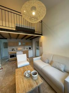 a living room with a couch and a table at Les Voyages du Loft, entre Eurexpo et St Exupéry in Genas