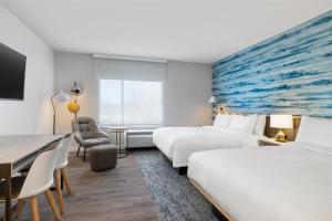GenevaにあるTownePlace Suites by Marriott Geneva at SPIRE Academyのベッド2台とデスクが備わるホテルルームです。