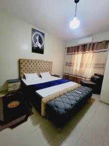 ein Schlafzimmer mit einem großen Bett und einem Sofa in der Unterkunft APPARTEMENT 2chambres salon ouest foire en bordure de la route in Dakar
