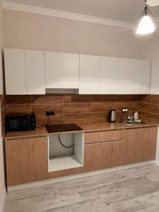 a kitchen with white cabinets and a sink at Уютная квартира рядом с вокзалом Нурлы-Жол in Promyshlennyy