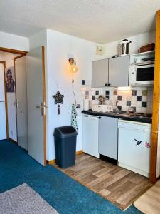 a kitchen with white appliances and a trash can at Résidence Soleil - 2 Pièces pour 5 Personnes 384 in Vénosc