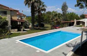 a swimming pool in front of a house at Posidi pool apartment in Possidi