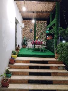 a patio with a table and a green floor and stairs at Seleucia DaR Umm Qais in Um Qeis
