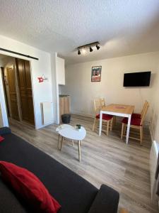 a living room with a couch and a table at Résidence Champame - Studio pour 4 Personnes 251 in Vénosc