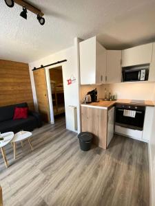a small living room with a couch and a kitchen at Résidence Champame - Studio pour 4 Personnes 251 in Vénosc