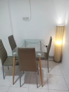 uma mesa de jantar em vidro com cadeiras e uma luz em CareforU Hostel Al mankhool Burjman metro em Ghantoot