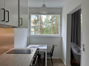 una pequeña cocina con mesa y ventana en Garden city studio, en Espoo
