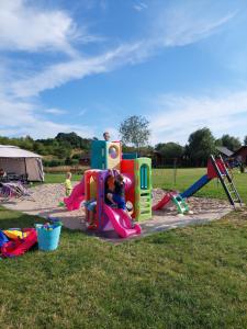 un bambino che gioca in un parco giochi con un'attrezzatura da gioco di Domki letniskowe Reda a Rusinowo