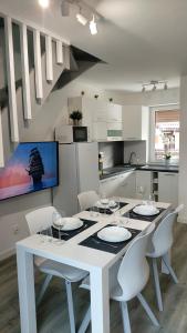 uma cozinha branca com uma mesa e cadeiras brancas em Domek Na pokładzie em Pogorzelica