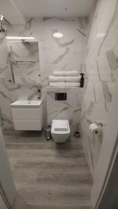 Un baño blanco con inodoro y lavabo. en Domek Na pokładzie, en Pogorzelica 19 fotos más