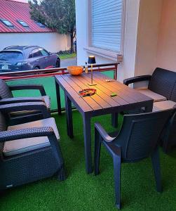 a wooden table and chairs on a patio at D&P WELLNESSHÁZ in Dabas