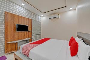 a bedroom with a bed and a tv on a wall at OYO The Castle Home Stay Inn in Jaipur