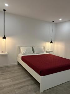 a white bedroom with a bed with a red blanket at CANAVESES RIVER HOUSE - ALOJAMENTO RURAL in Marco de Canaveses