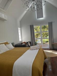 - une chambre avec un grand lit et un lustre dans l'établissement Memory Lane Accommodation, à Mount Tamborine