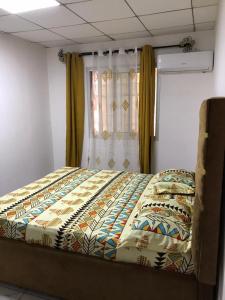 a large bed in a room with a window at DAC IMMOBILIER in Yaoundé