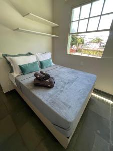 Una cama con una maleta encima. en Residencial Via do Café, en Ribeirão Preto