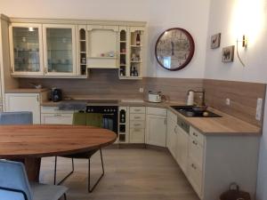 a kitchen with white cabinets and a wooden table at SistiHome in Kleinfeistritz