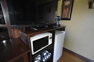 a kitchen with a microwave and a television on a table at Motel ANF in Drummondville
